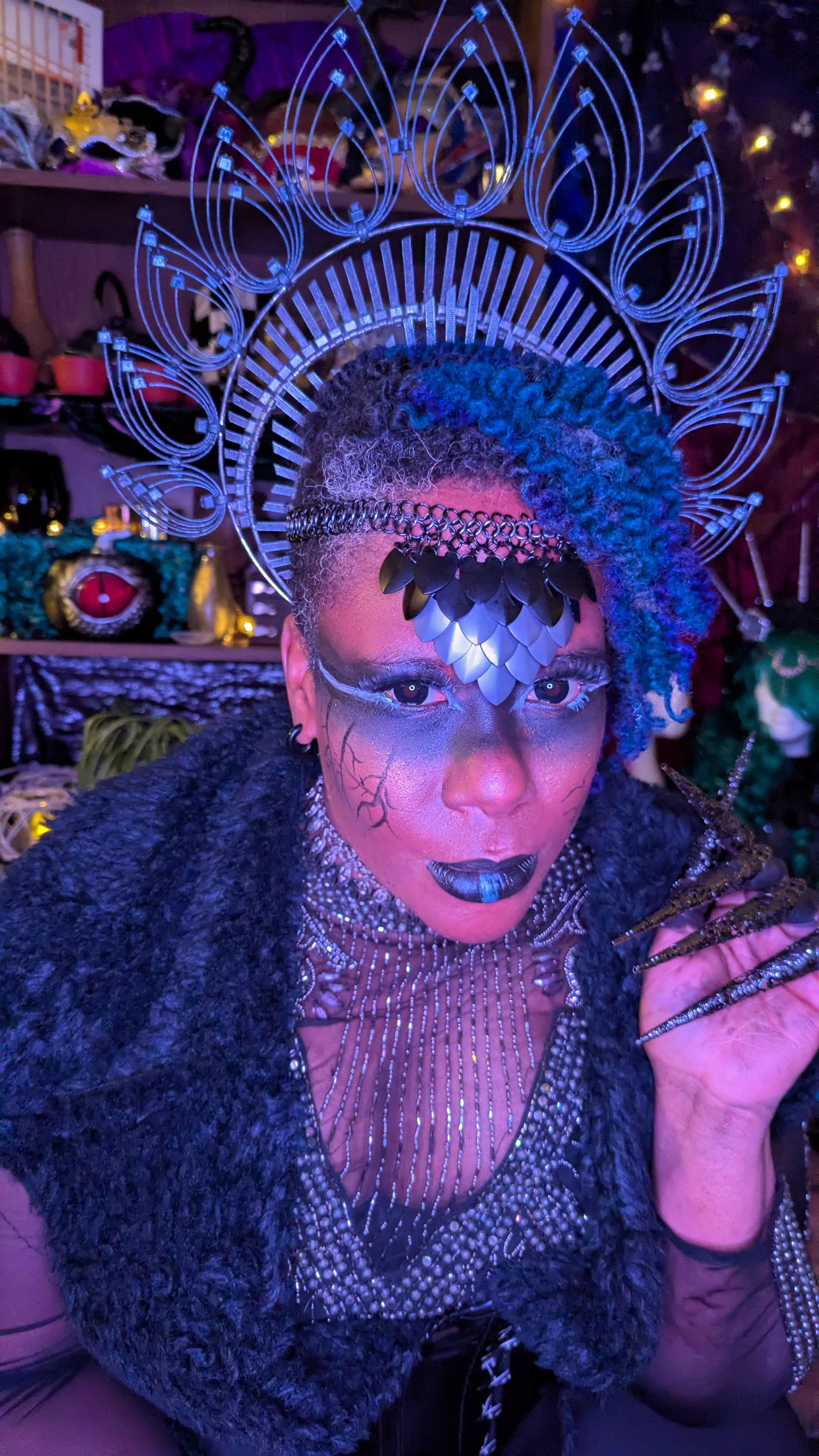 An image of a black woman in a dark fantasy outfit, featuring a chain mail and scale mail crown.